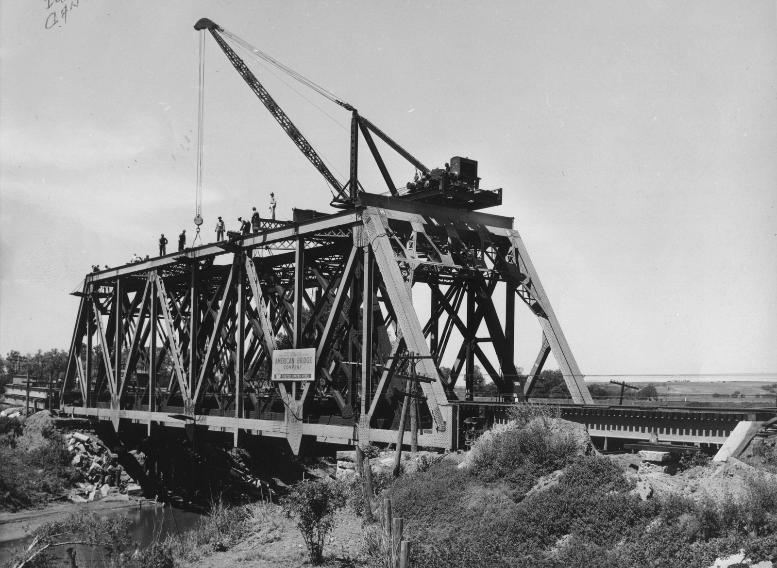 Construction photo of bridge, showing unique method of erecting truss around previous bridge